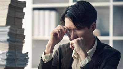 多くの書物を抱えて、悩んでいる男性